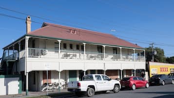 A two-story building with a balcony, a red roof, and a sign indicating a 2P parking area.