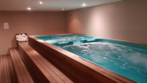 A spa area with a wooden bench and a hot tub.