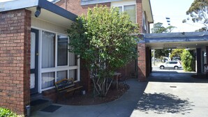 A two-story brick building with a covered entrance and a small tree in front. - Kardinia Park Motel (Newtown)