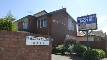 A brick motel with a sign reading "Kardinia Park Motel" and another sign stating "VACANCY".