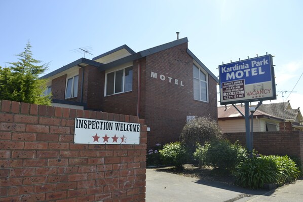 A brick motel with a sign reading "Kardinia Park Motel" and another sign stating "VACANCY".