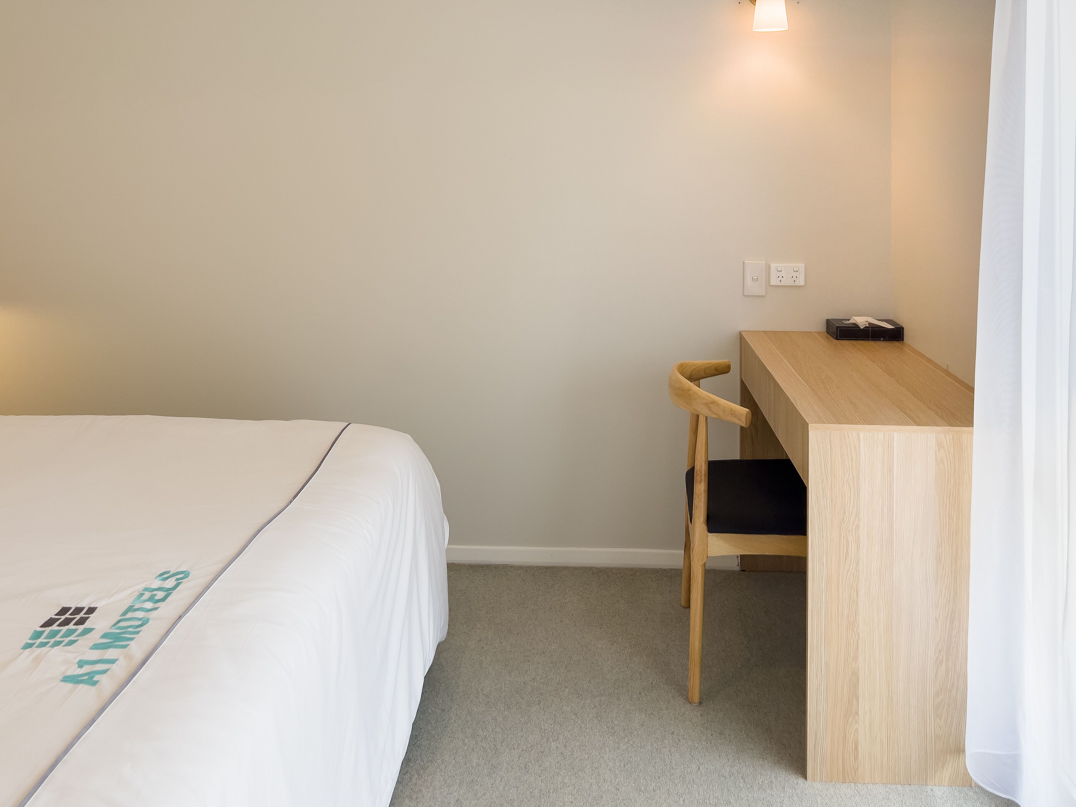 Ein Hotelzimmer mit Bett, Schreibtisch und Stuhl.