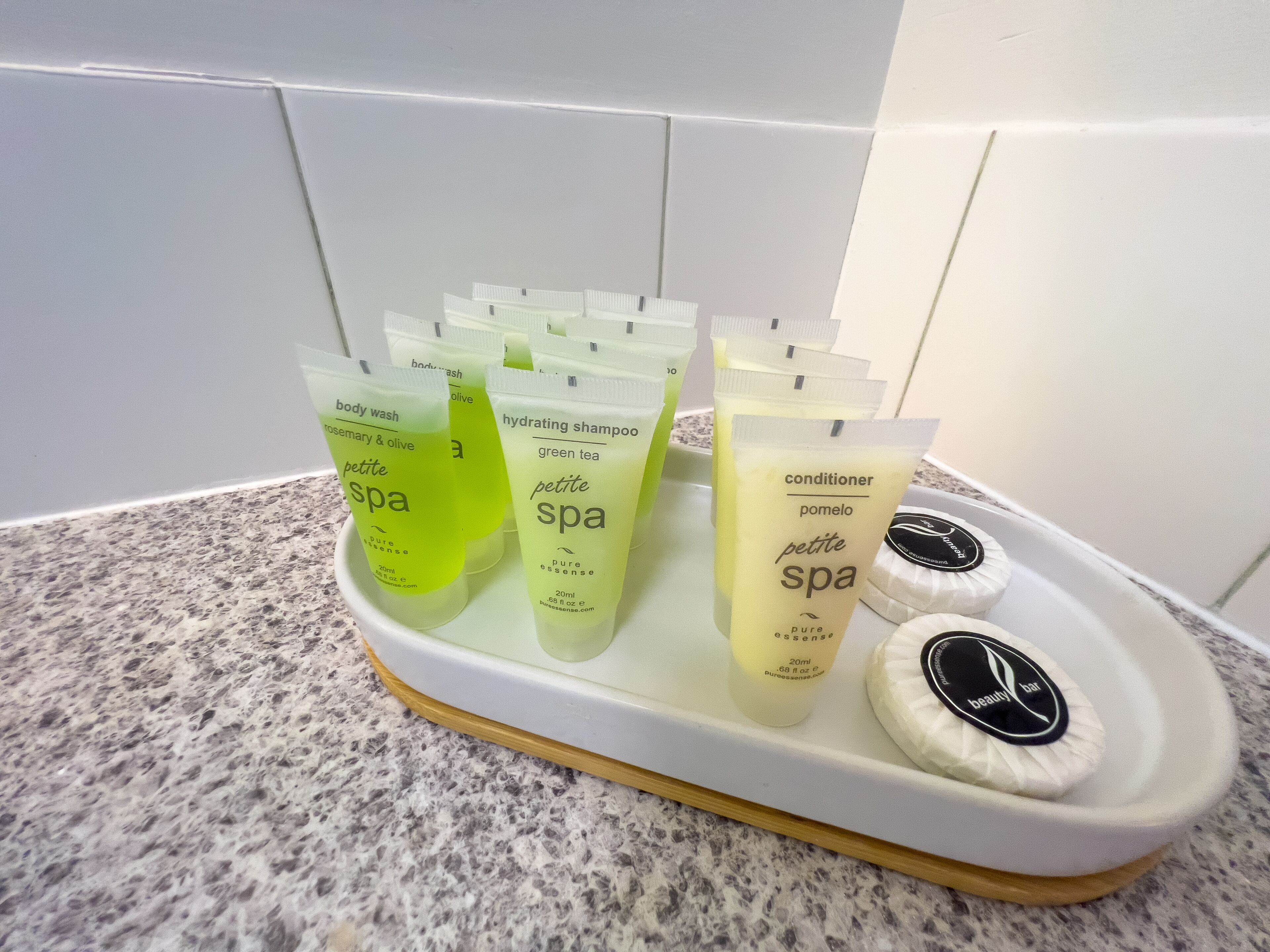 Una bandeja con varios productos de spa, como jabón de baño, champú y acondicionador.