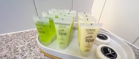 A tray with multiple spa products including body wash, shampoo, and conditioner.
