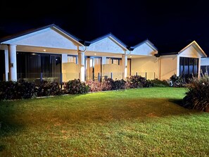 A modern two-story house with a well-maintained lawn and a patio area.
