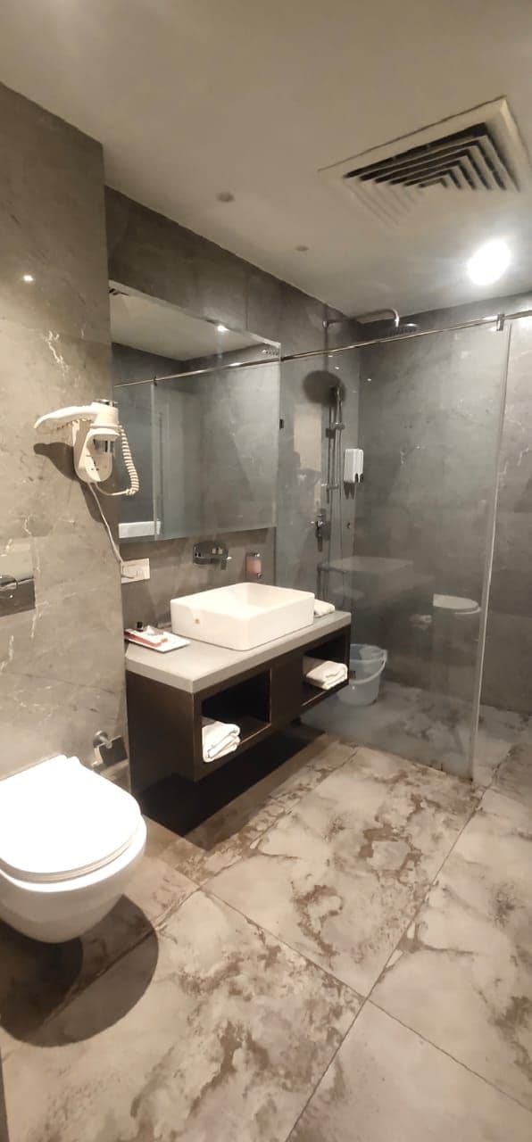 A modern bathroom with a shower, toilet, and vanity.