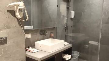 A modern bathroom with a shower, toilet, and vanity.