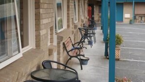 A building with a covered outdoor seating area, featuring tables and chairs. - Peppinella Motel (Delacombe)