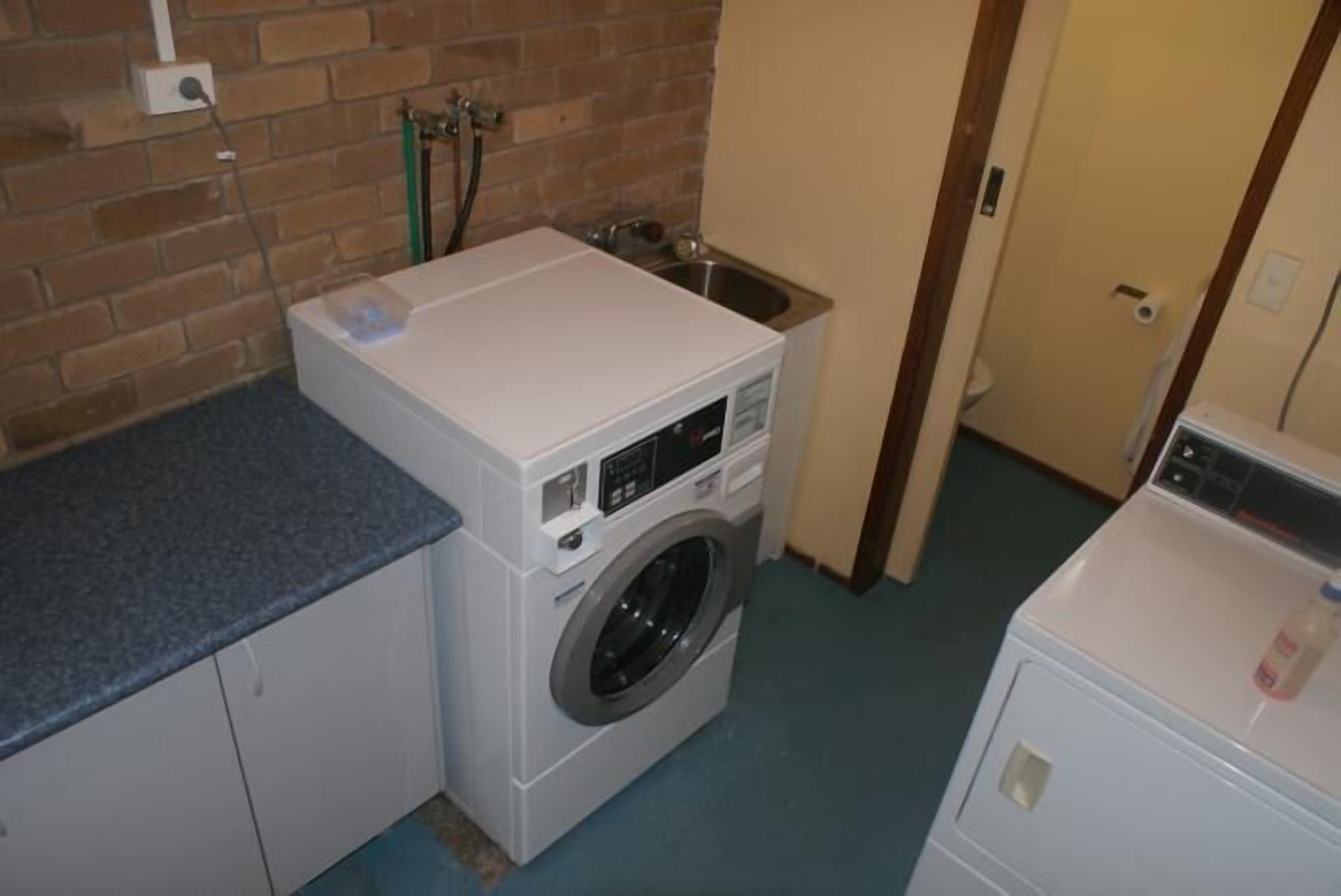 A laundry area with a washing machine, a dryer, and a sink.