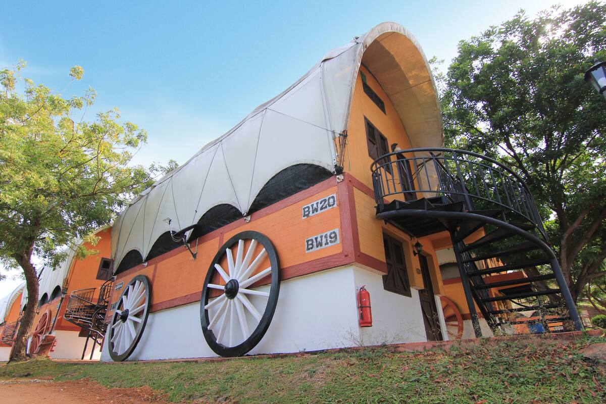 A building with large wheels, a staircase, and a fire extinguisher.