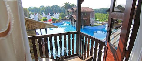 A balcony with a view of a swimming pool and several tents.