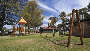 A playground with swings and a small shelter.