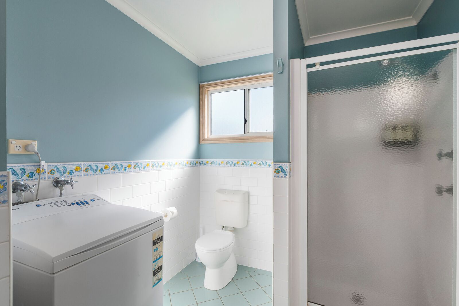 A bathroom with a white sink, a toilet, and a shower area.
