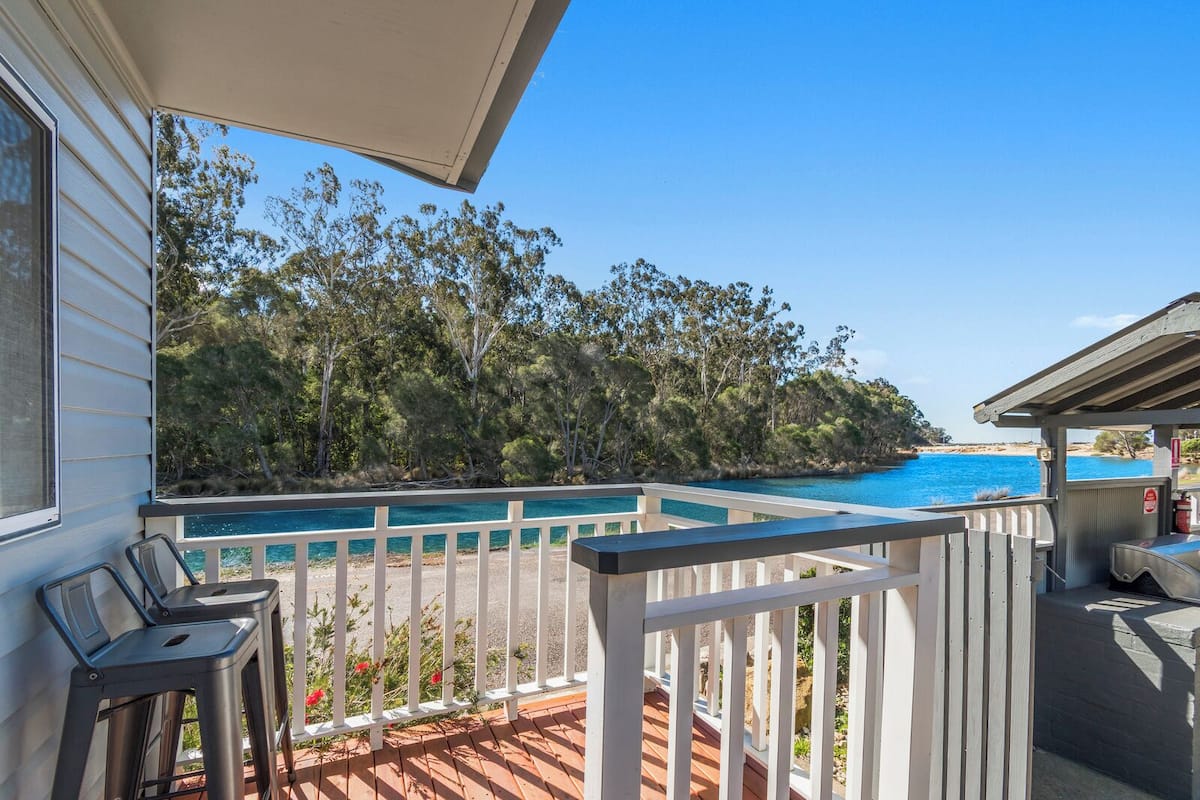 Un balcon avec vue sur une piscine et une plage.