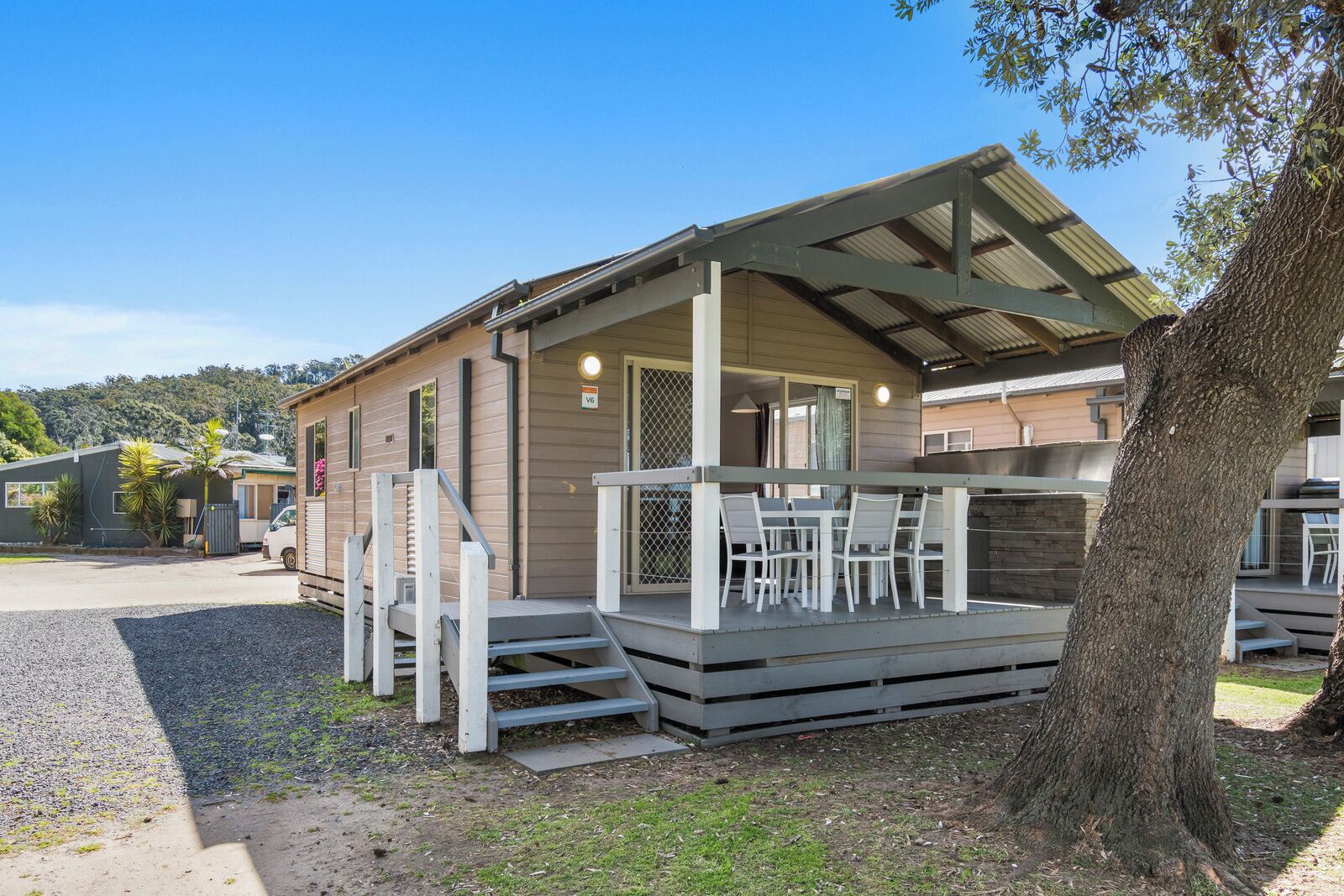 A single-story building with a covered porch and a small outdoor seating area.