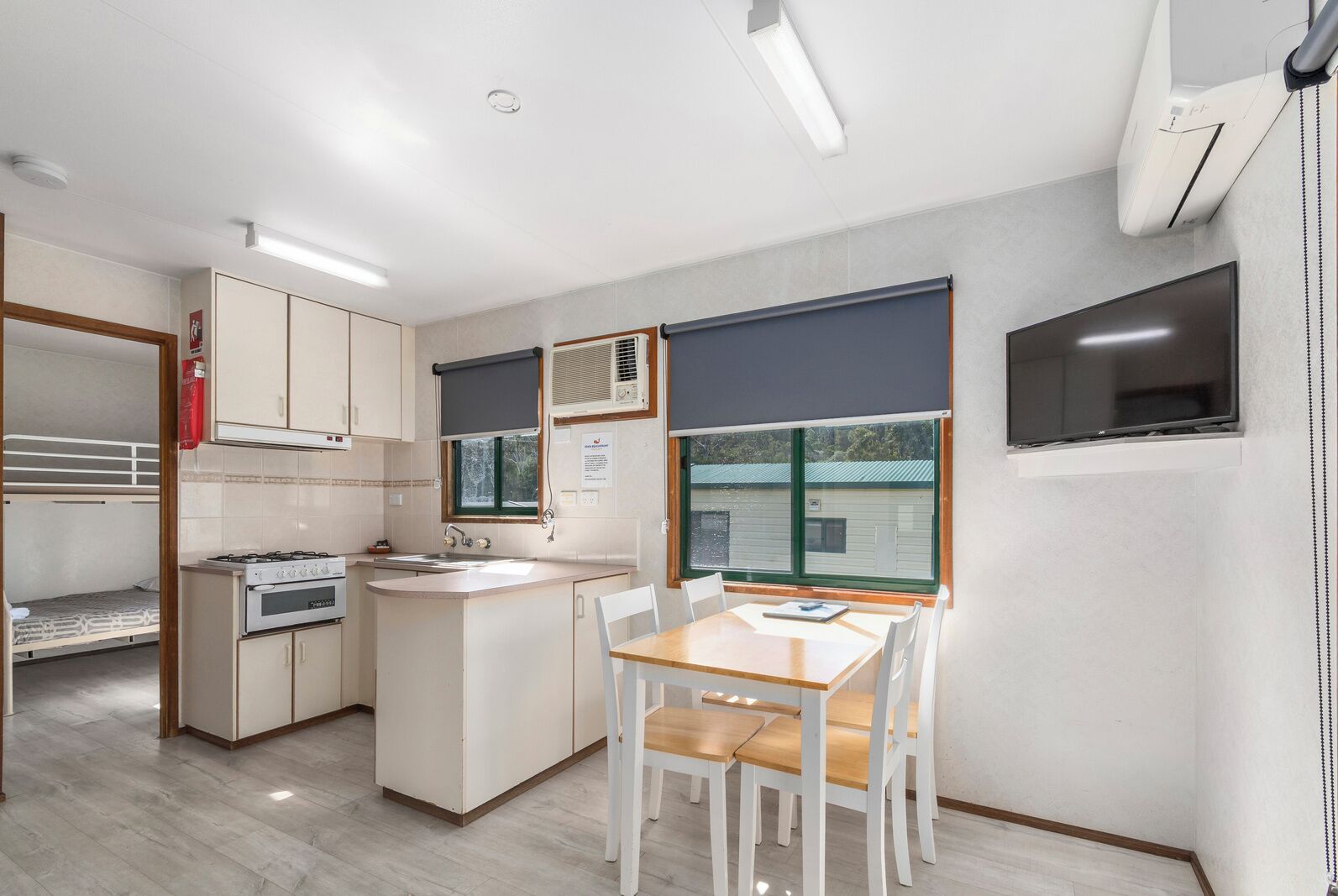 Cocina compacta con estufa, lavamanos y comedor.