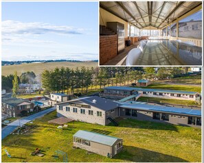 A modern motor inn with a spacious outdoor area, a covered dining area, and a view of the surrounding landscape.