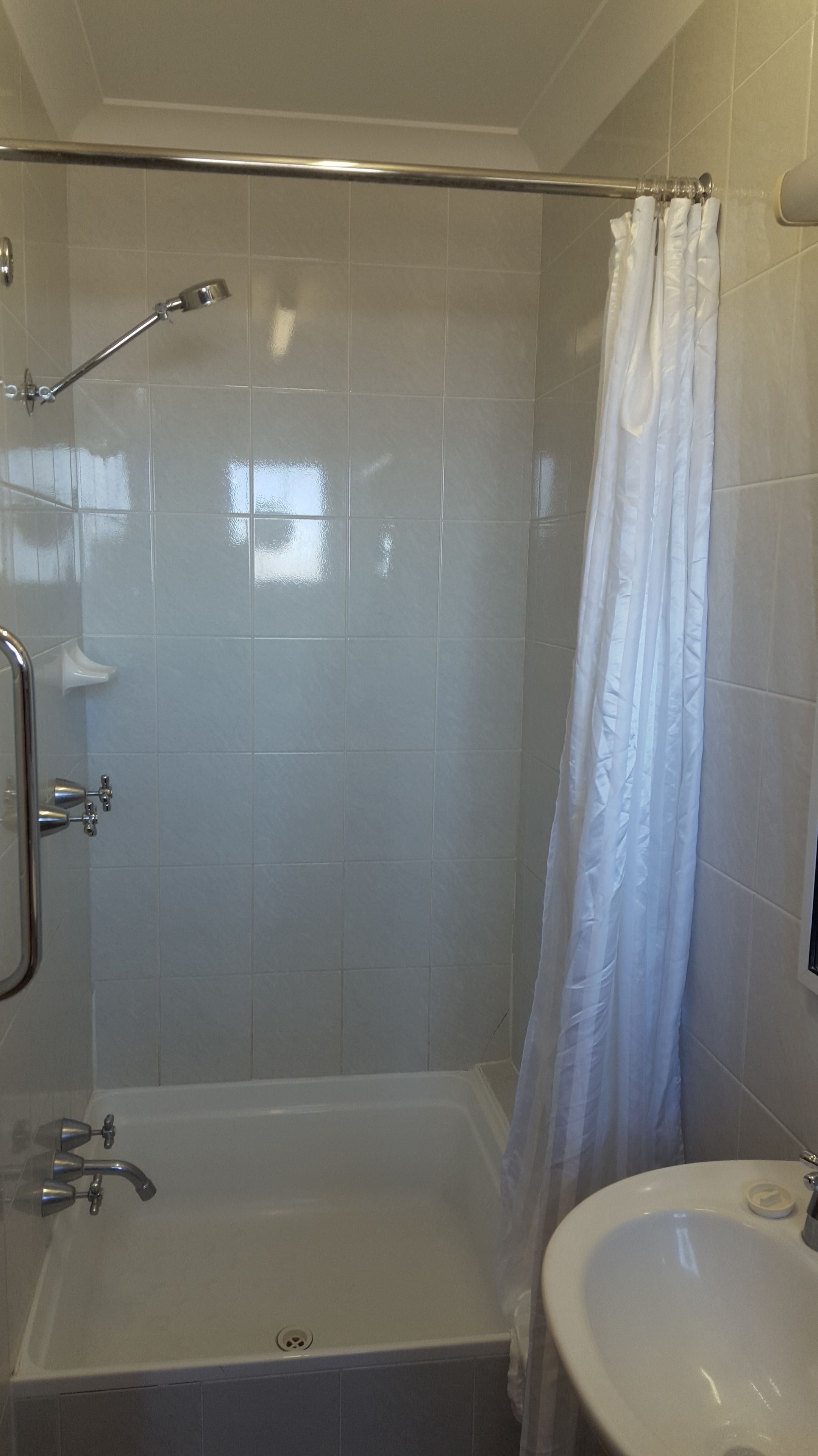 Une salle de bain avec une douche, une baignoire et un lavabo.