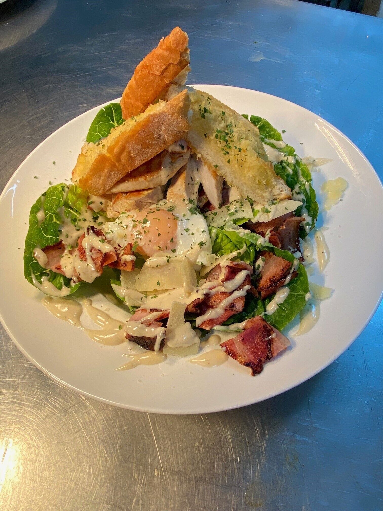 Een bord eten met een sandwich, salade en gepocheerd ei.