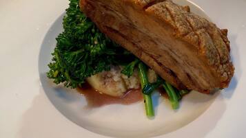 A plate with a piece of meat, broccoli, and mashed potatoes.