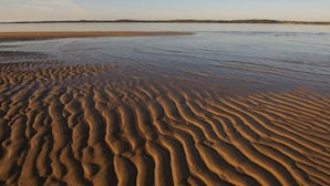 A beach with rippled sand patterns and a calm water body. - Broadbeach Inverloch Resort (Inverloch)