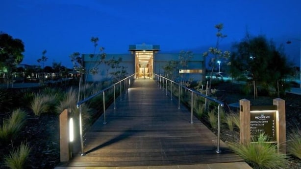 A wooden pathway leading to a building entrance at dusk. - Broadbeach Inverloch Resort (Inverloch)