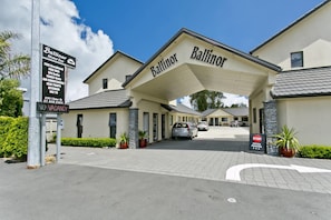Ballinor Motor Inn -hotellissa on katettu sisäänkäynti, pysäköintialue ja kyltti, jossa kerrotaan hotellin tarjoamista palveluista, kuten ilmaisesta laajakaistayhteydestä ja ilmastoinnista.