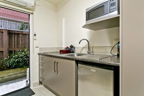Suite familiar, 2 dormitoris, banyera d'hidromassatge, zona de pati | Cuina privada | Frigorífic, microones, placa de cuina i cafetera i tetera 