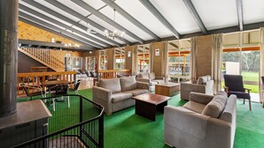 A spacious indoor area with multiple seating options including sofas and chairs, a staircase, and a view of the outdoors through large windows. - Mansfield Country Resort (Mansfield)