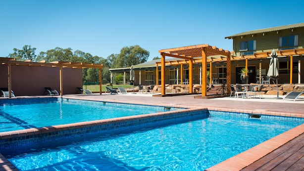 A rectangular swimming pool with a wooden deck and lounge chairs. - Mansfield Country Resort (Mansfield)