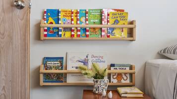 Cozy reading nook with a bookshelf featuring a variety of children's books and a framed family photo.
