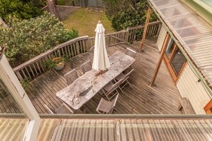 A wooden deck with a table and chairs, surrounded by a wooden railing. - Mandala Bruny Island (Alonnah)