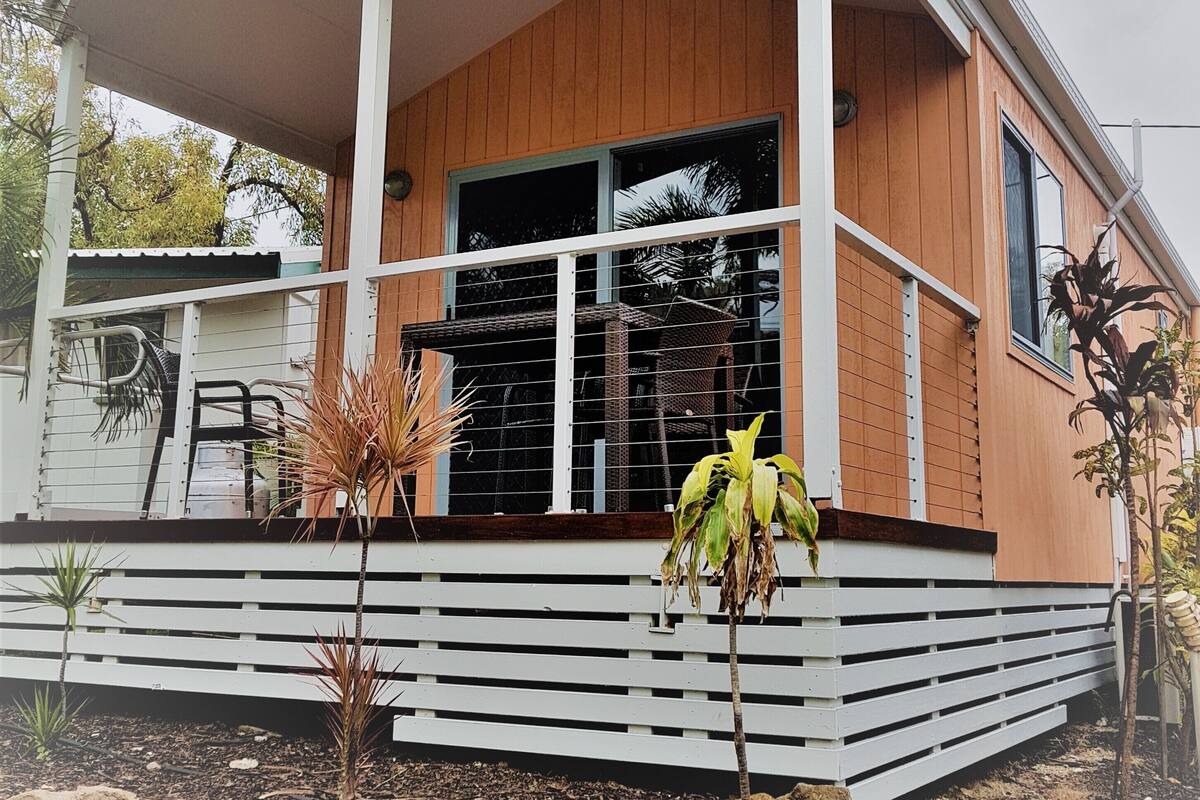 A modern house with a covered porch, large windows, and a wooden exterior.