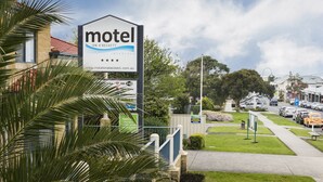 A motel sign with a website address, free Wi-Fi, and a parking sign. - Motel on A'beckett (Inverloch)