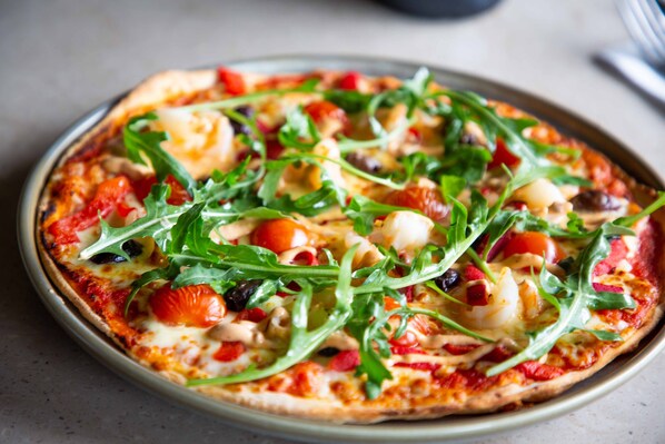 A pizza with various toppings on a plate.