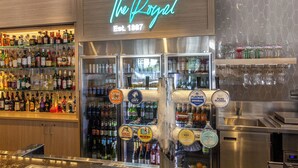 A bar area with a neon sign reading "The Royal" and a selection of liquor bottles. - Royal Hotel Randwick (Randwick)