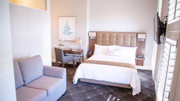 Una habitación de hotel con una cama, un sofá, un escritorio y una silla.