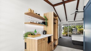 Eine moderne Küche mit Holzschränken, einer weißen Arbeitsplatte und einem integrierten Weinkühlschrank.