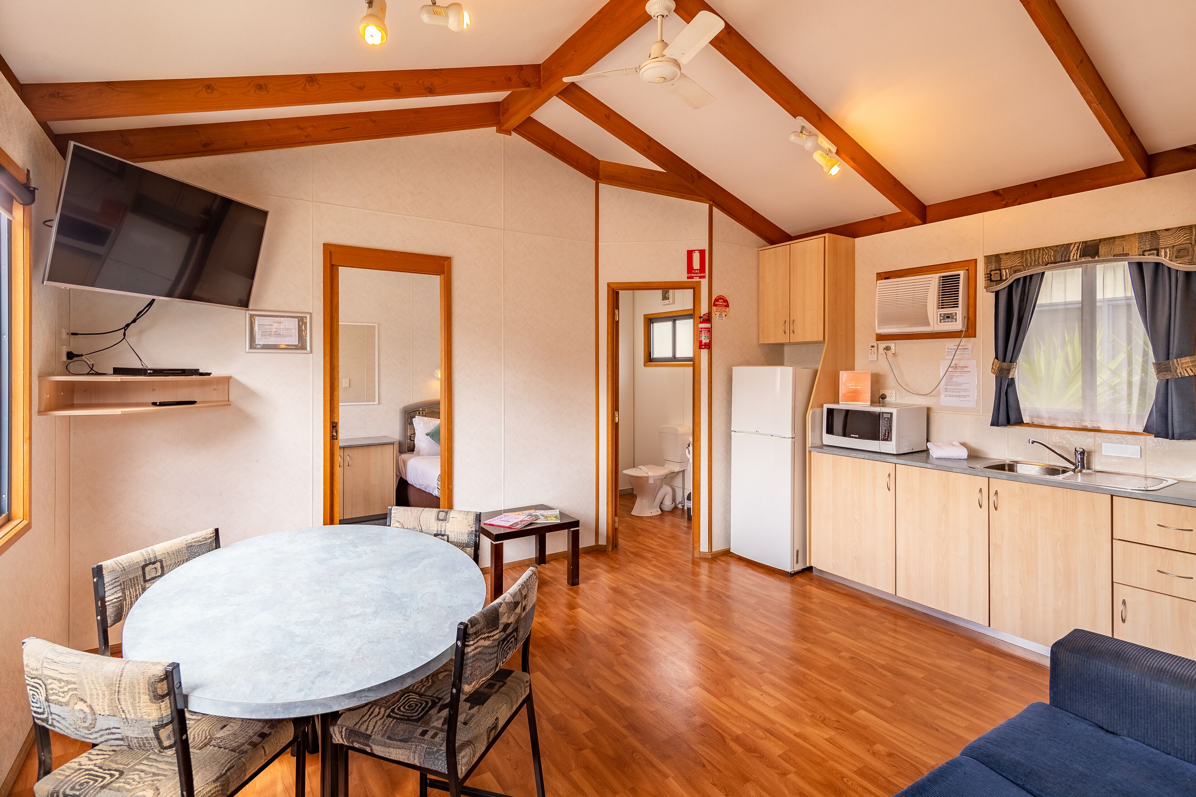 A compact kitchen with wooden cabinets, a microwave, and a sink.