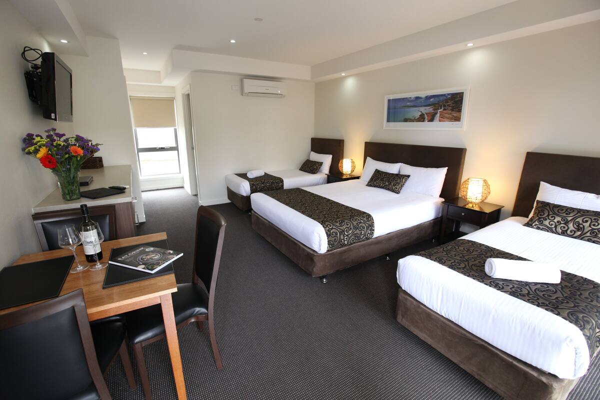 Deluxe driepersoonskamer | Luxe beddengoed, een minibar, een bureau, een strijkplank/strijkijzer