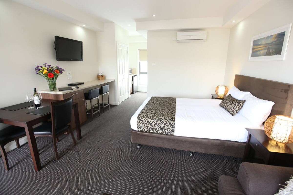Deluxe kamer, niet-roken, kitchenette (Deluxe Queen) | Luxe beddengoed, een minibar, een bureau, een strijkplank/strijkijzer