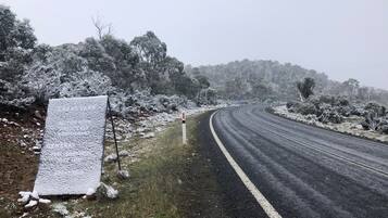 A road with snow-covered surroundings and a signpost.