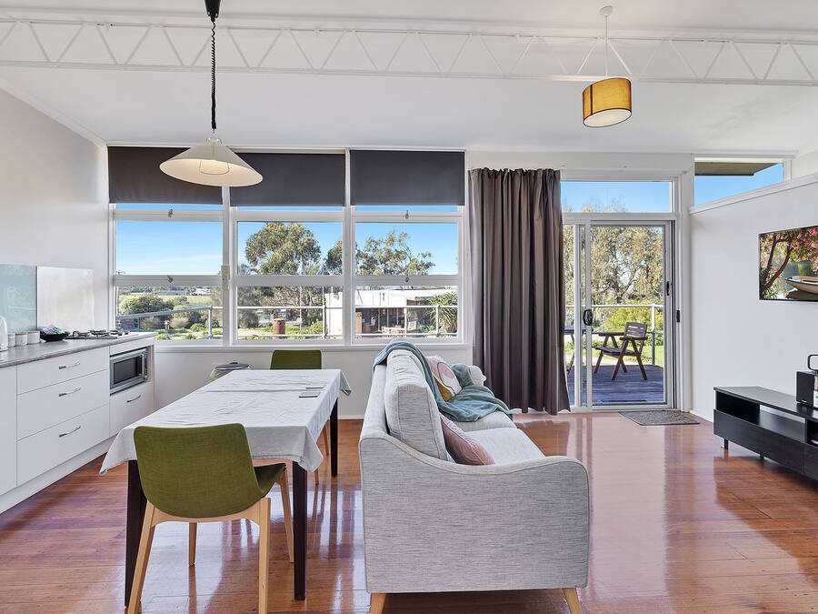 Una cocina moderna con comedor, ventanas amplias y vistas al exterior.