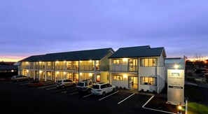 Un motel à étages, un parking avec plusieurs voitures et un panneau indiquant qu’il s’agit du Lincoln Motel, situé sur la rue Maurice.