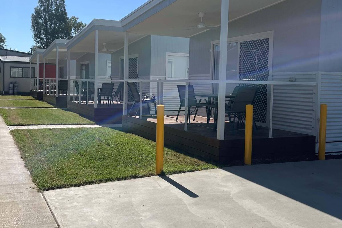 Uma fileira de casas móveis com varandas, cada uma com ventoinha no teto e área de estar externa.