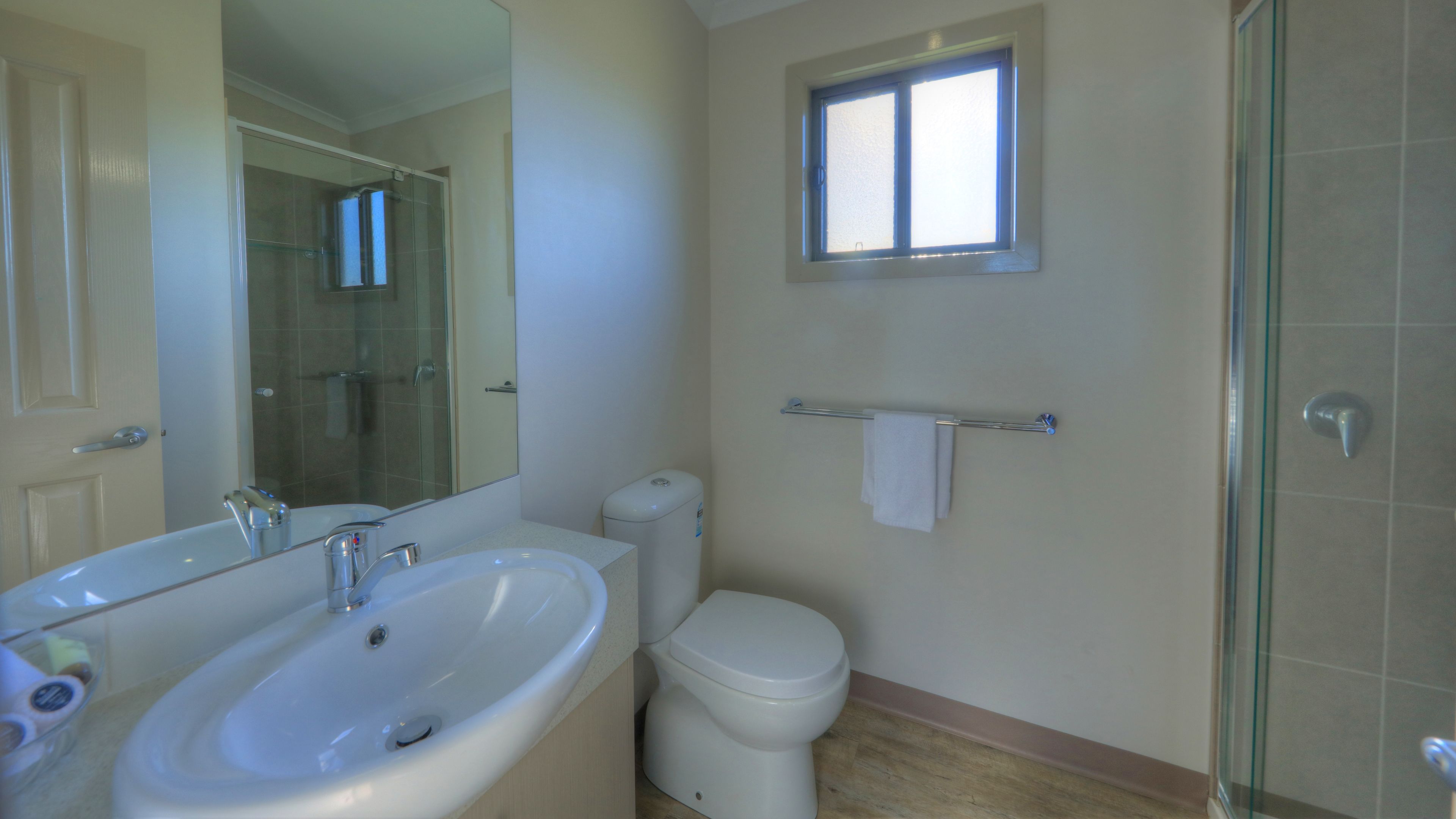 Une salle de bain avec un grand lavabo, des toilettes et une douche à parois de verre.