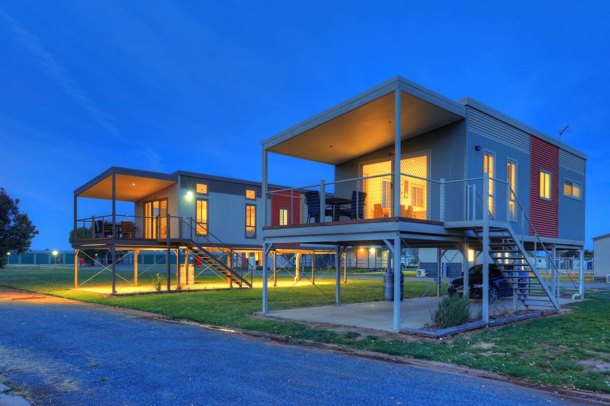 Uma casa moderna de dois andares com varanda coberta e garagem separada.