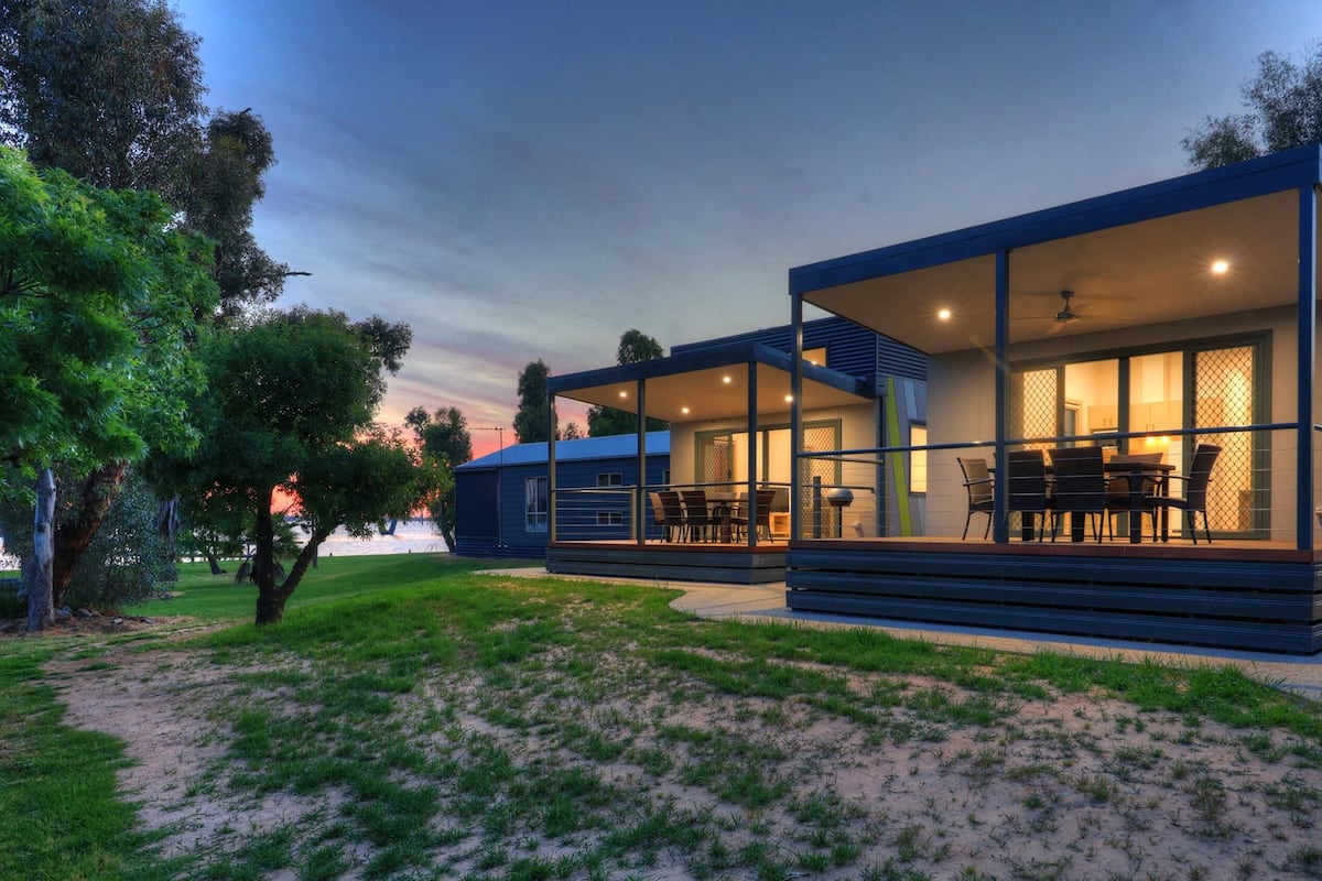 Uma casa moderna com varanda coberta e área de jantar.