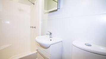 Een badkamer met een witte badkuip, een wastafel en een toilet.