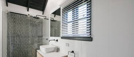 Een moderne badkamer met een douche, een wastafel en een toilet.